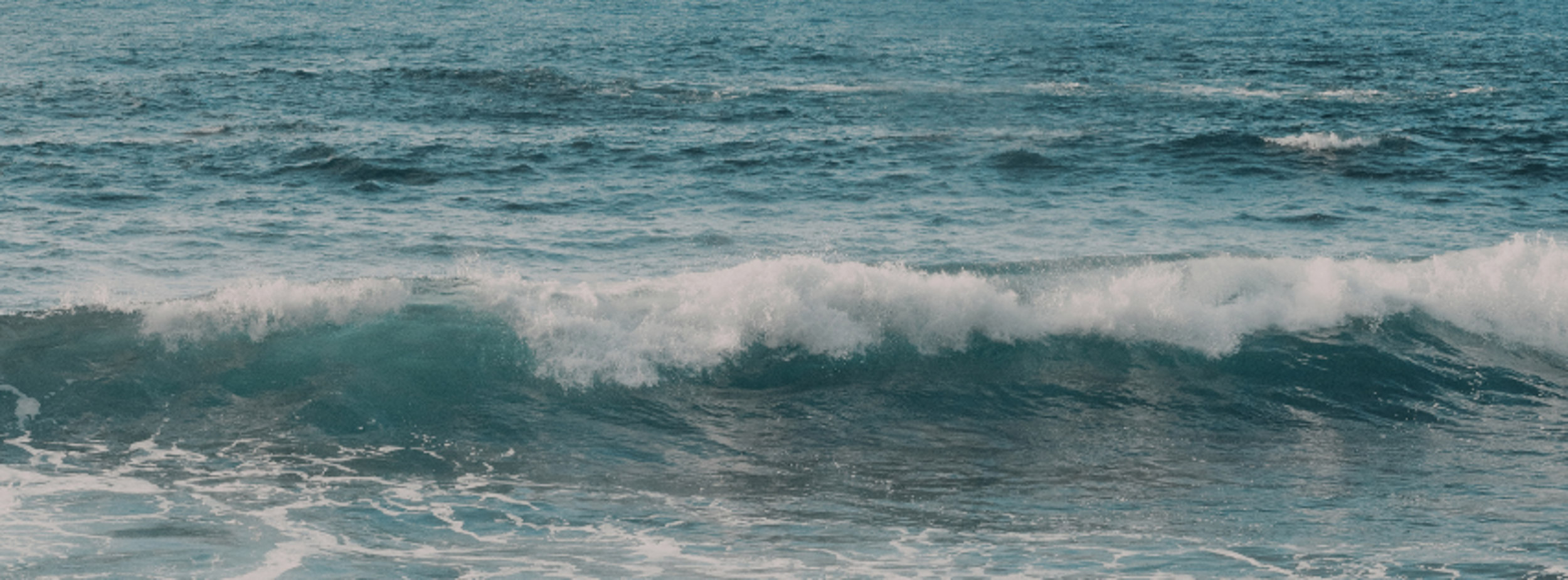 Blue ocean wave moving towards shore